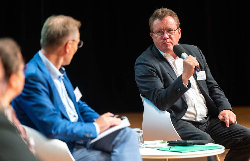 drei Menschen bei einer Podiumsdiskussion