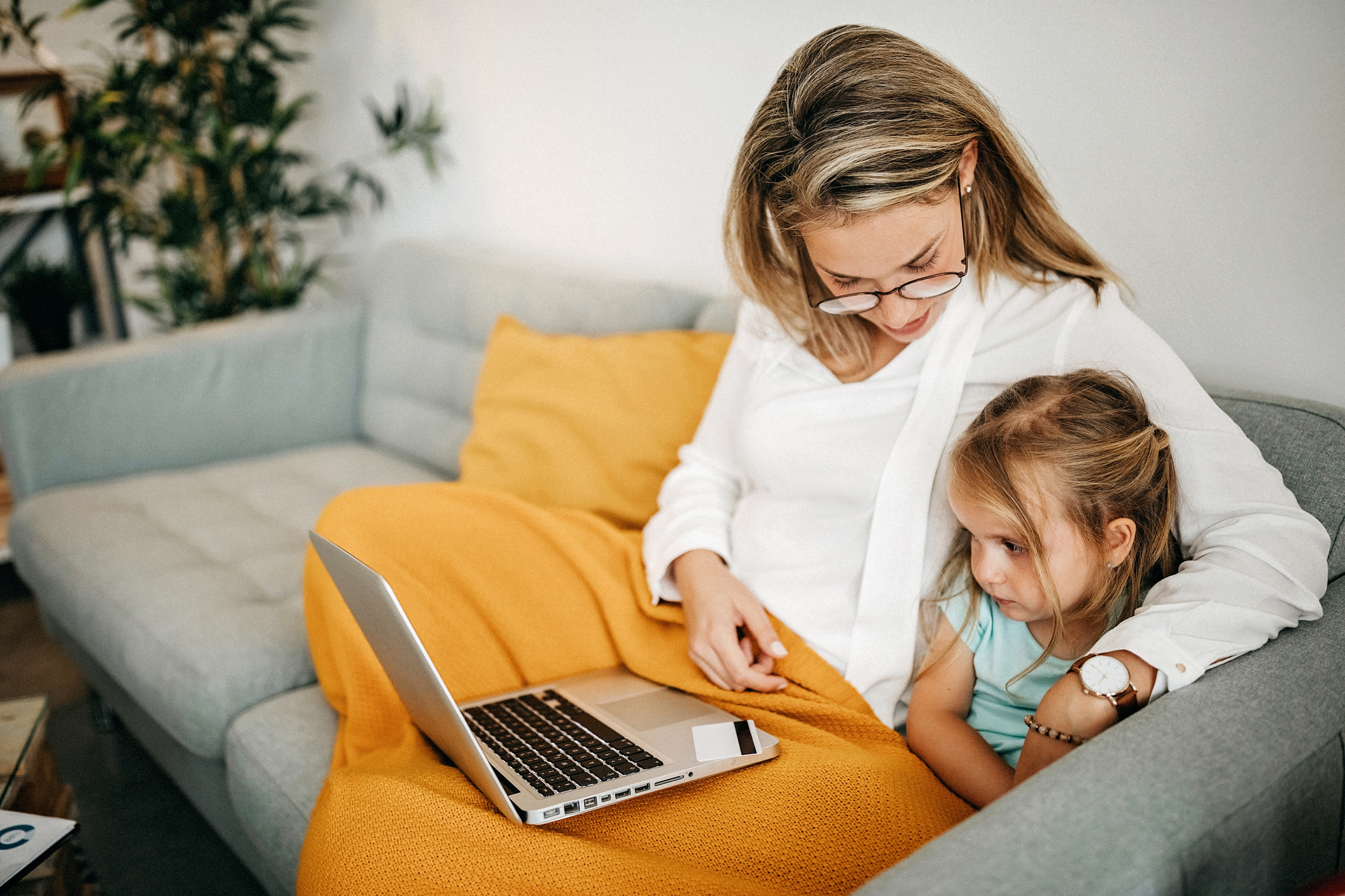 Mutter mit Kind schauen auf Laptop